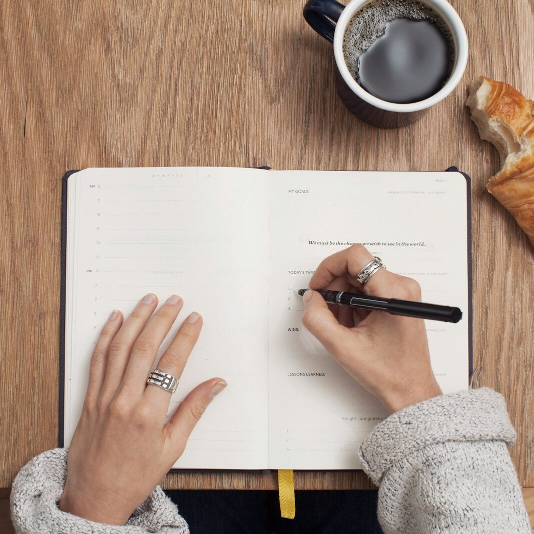 person writing on a book